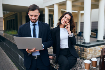 young smart man taking part in the web conference while woman is making a phone call