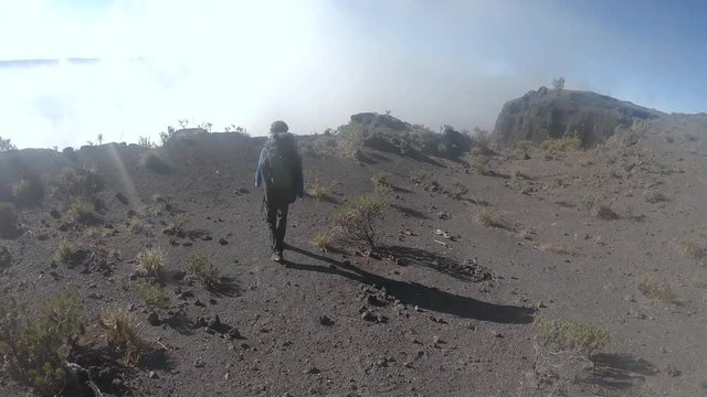 Climbing the crater of Tambora volcano. Backpacker walking around Tambora crater on the top of mountain. Sumbawa island, Indonesia 