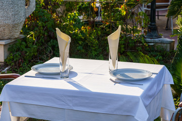 table for two with a white tablecloth in a street restaurant, selective focus