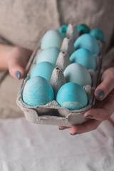 Easter eggs painted in blue natural color in woman hands
