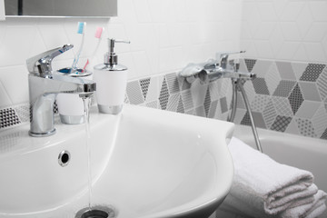 Bathroom, body care products and towel. Bath preparation. White interior of bathroom. Shampoo, shower gel and other bathing accessories. Toothbrush and soap dispenser. details of bathroom interior