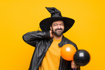 Man with witch hat holding black and orange air balloons for halloween party with neckache