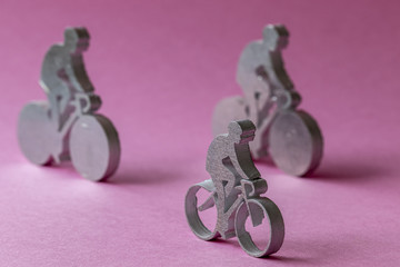 Figurines de cyclistes en métal sur fond rose