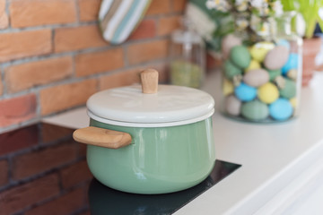 Saucepan on the table, kitchen in loft style, decorated for Easter,