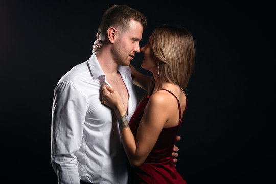 Fashion photo of sexy luxurious elegant couple in the tender passion indoors. close up portrait, relatioship, isolated black background, studio shot.