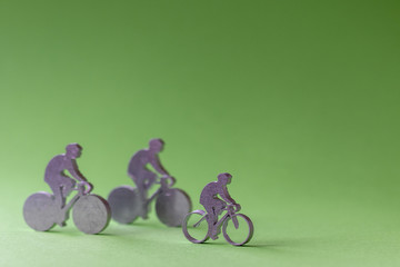 Figurines de cyclistes en métal sur fond vert