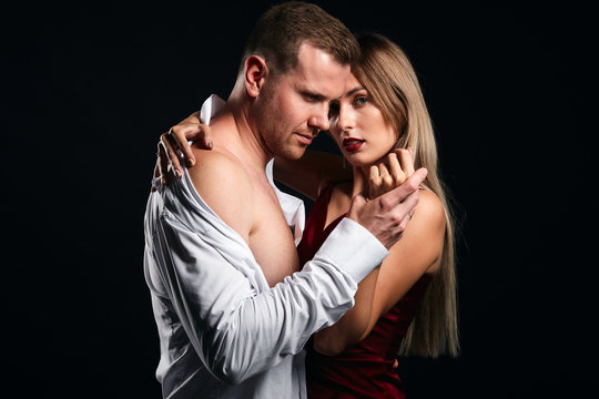 young people languish for love, isolated black background, studio shot. display of love , amorous man holding his woman's hand, going to kiss it