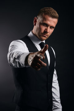 Handsome confident businessman pointing finger at the camera. isolated black background, studio shot. lifestyle, best choice. close up portrait.