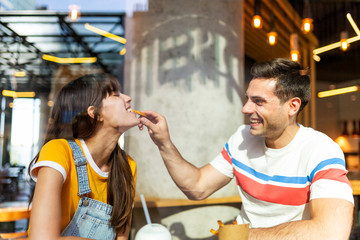 cute couple with man putting food in woman mouth