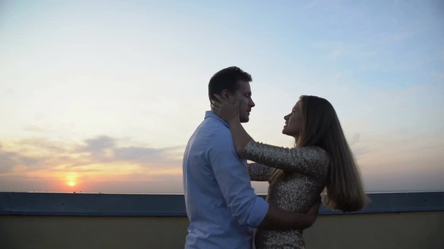 Loving couple dancing on roof top, romantic date on sunset, relationship