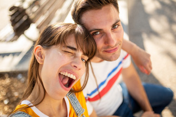 two friends sitting outside young woman winking eye