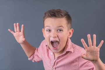 funny brunette boy is building a frightening face, the concept of children's emotions