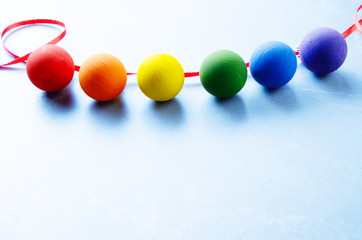 Hand made painted Christmas decoration balls in colors of rainbow on stone table