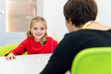 Elementary Age Girl in Child Occupational Therapy Session Doing Playful Exercises With Her...