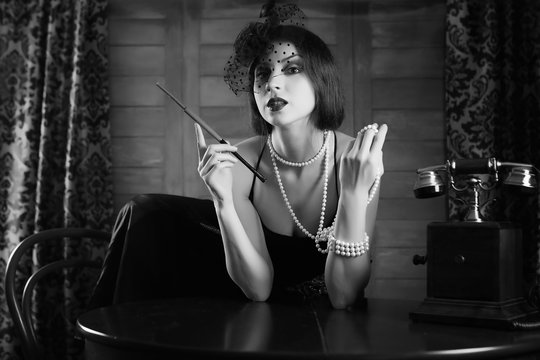 Beautiful 1930s girl smokes monochrome