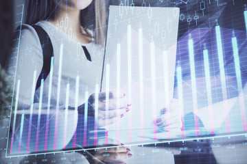 Double exposure of hands making notes with forex chart huds. Stock market concept.