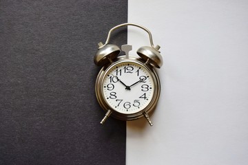 one alarm clock rings the time to get up in the morning on a black and white background.