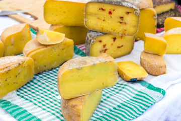 hard cheeses sliced on a wooden board on a dark rustic background