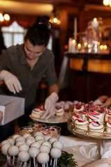 festive table with sweets and a variety of sweet snacks against the backdrop of  a girl confectioner