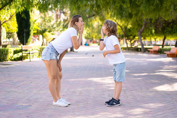 Mother and son in a park doing surprise gesture