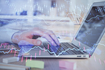 Double exposure of stock market graph with man working on laptop on background. Concept of financial analysis.