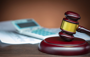 wooden gavel and calculator on table
