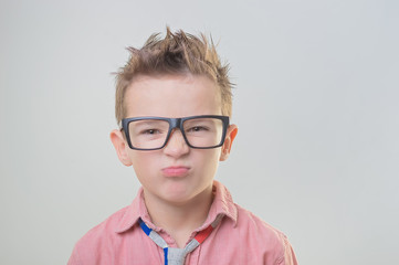 Cute stylish boy in glasses with disagree face