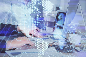 Multi exposure of chart with man typing on computer in office on background. Concept of hard work.