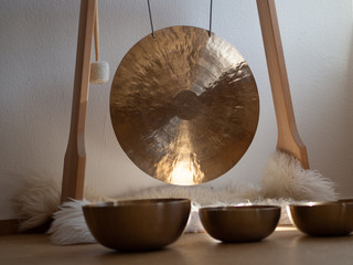Gong in a wooden stand with tibetian singing bowls for sound bath - obrazy, fototapety, plakaty