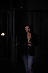 brunette in a black jacket with a glass of red wine