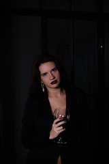 brunette in a black jacket with a glass of red wine