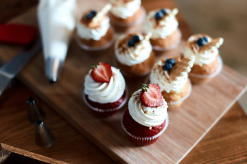 Delicious beautiful vanilla cupcakes with strawberries. close up cropped photo.tasty treat