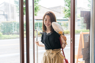 ハンズフリー扇風機を使う若い女性