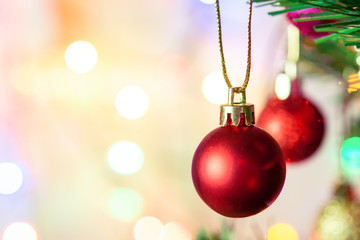 Christmas decoration. Hanging red balls on pine branches Christmas tree garland and ornaments over abstract bokeh background with copy space.