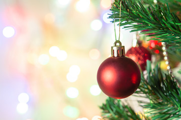 Christmas decoration. Hanging red balls on pine branches Christmas tree garland and ornaments over abstract bokeh background with copy space.