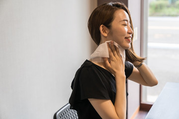 ハンズフリー扇風機を使う若い女性