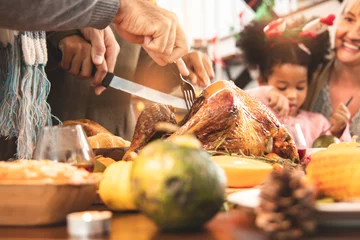 Poster Thanksgiving Celebration Tradition Family Dinner Concept.family having holiday dinner and cutting turkey.Young black adult woman and her daughter happy.. © anon