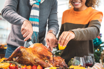 Thanksgiving Celebration Tradition Family Dinner Concept.family having holiday dinner and cutting turkey.Young black adult woman and her daughter happy..