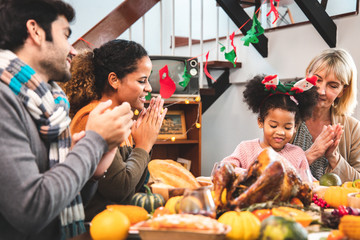 Thanksgiving Celebration Tradition Family Dinner Concept.family having holiday dinner and cutting turkey.Young black adult woman and her daughter happy..