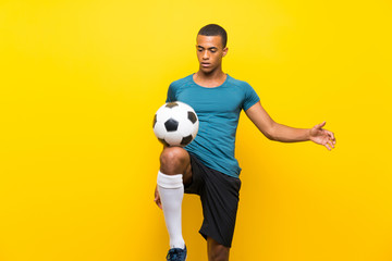 Afro American football player man over isolated yellow background
