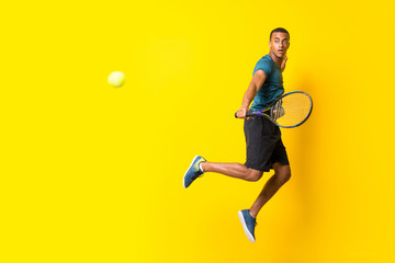 Fototapeta na wymiar Afro American tennis player man over isolated yellow background