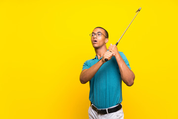 Afro American golfer player man over isolated yellow background