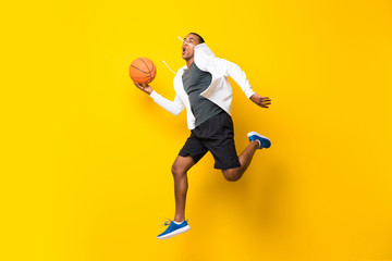 Fototapeta na wymiar Afro American basketball player man over isolated yellow background