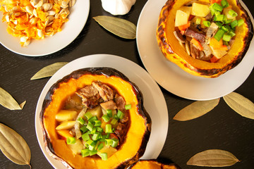Baked pumpkin stuffed with meat and vegetables on a dark wooden background. Beef stew with vegetables in pumpkin. Baked pumpkin food 