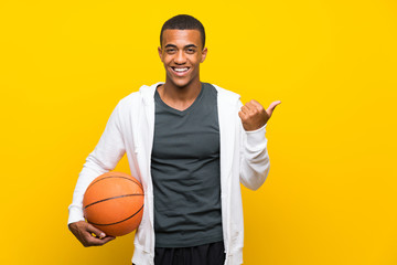 African American basketball player man pointing to the side to present a product