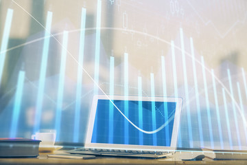 Forex graph hologram on table with computer background. Multi exposure. Concept of financial markets.