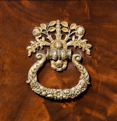 Antique brass elaborate handle on wood background