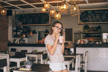 Teen girl drinking smoothie in cafe