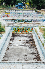 une vieille piscine abandonnée. Des tags et des graffitis dans une piscine.