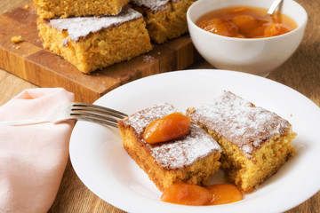 Pieces of cake on a white plate and apricot jam